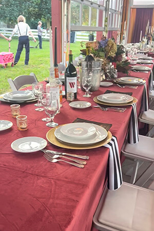a long table is set with plates and silverware for a charity event