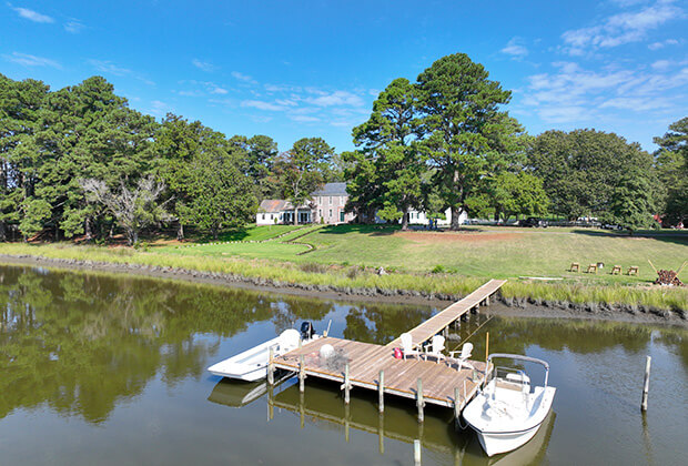 two boats parked at the dock in front of the main manor house at vaux hall farm