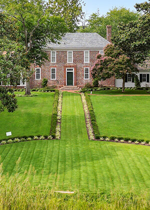 a green lawn leads up to the front steps of the vaux hall manor house